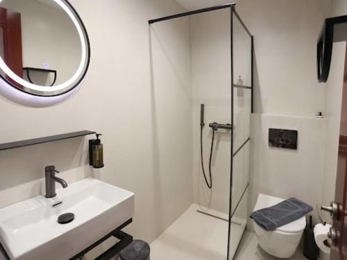 a white bathroom with a sink and a shower at Villa Anna in Hanioti