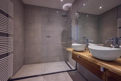 un baño con dos lavabos y una ducha en Hotel Duinrand Drunen, en Drunen
