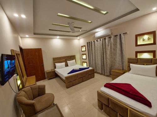 a hotel room with two beds and a television at The Oak Residence in Islamabad