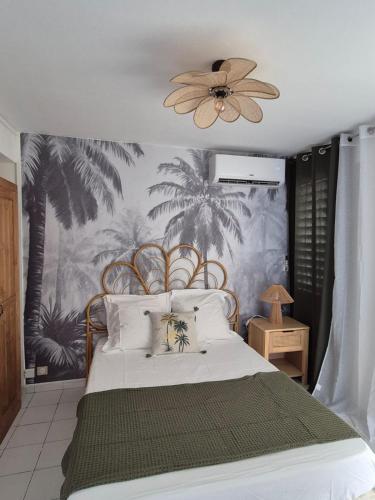 a bedroom with a large bed with a fan at Kreyol Chic in Le Gosier