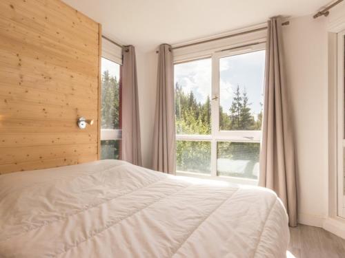 a bedroom with a bed and a large window at Appartement spacieux 8 pers, balcon, centre station - FR-1-346-400 in Arc 1800