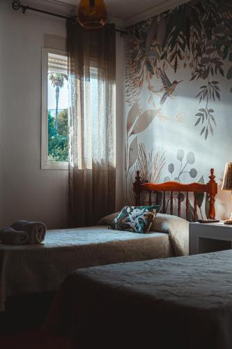 a bedroom with two beds and a window at Hostal Boutique El Rey del Sol in Alora
