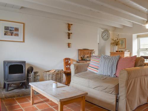 een woonkamer met een bank en een fornuis bij Rowan Cottage in Rosedale Abbey