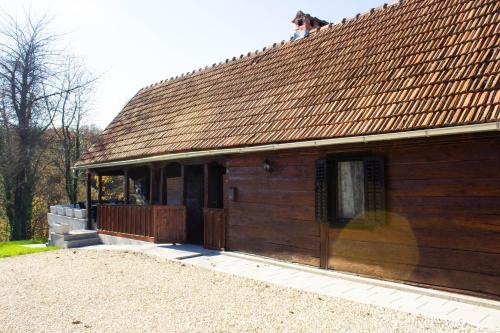 ein Holzgebäude mit einem Dach und einer Veranda in der Unterkunft Aurora Silvae 