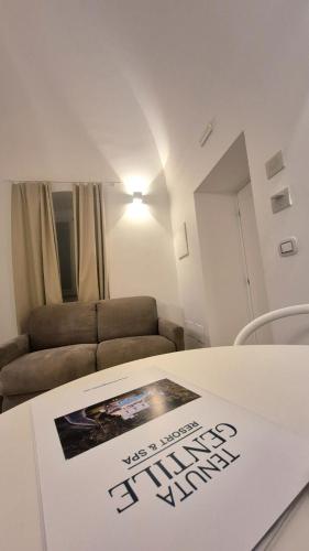 a living room with a couch and a table with a poster on it at VILLA GENTILE RESORT E SPA in Cassano delle Murge