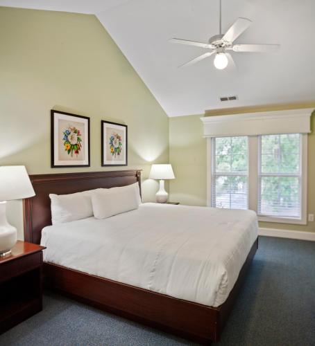 a bedroom with a large bed and a ceiling fan at King's Creek Resort by Spinnaker in Williamsburg
