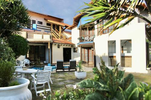 un patio d'une maison avec des chaises et une table dans l'établissement Pousada Kaianoá, à Arraial do Cabo