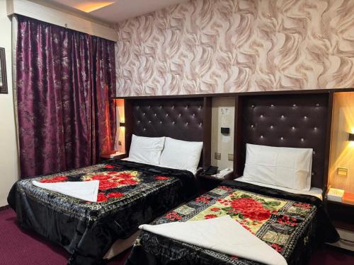 ein Hotelzimmer mit 2 Betten und Vorhängen in der Unterkunft Quality Hotel Apartments in Sabkhah