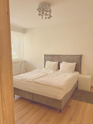 a bed with white sheets and pillows in a bedroom at Trio Apartments in Ostrava