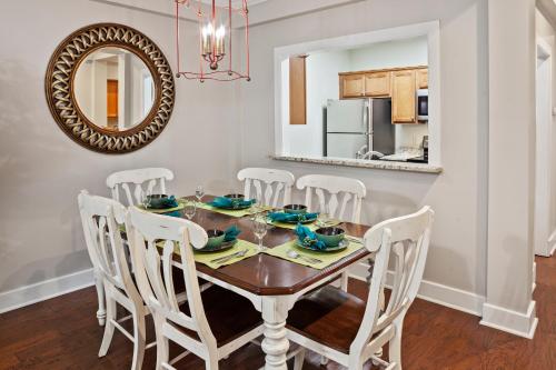 a dining room with a table with chairs and a mirror at King's Creek Resort by Spinnaker in Williamsburg