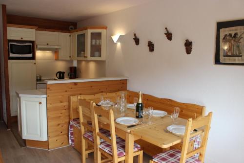 une salle à manger avec une table et des chaises et une cuisine dans l'établissement Beausoleil Appartements VTI, à Val Thorens