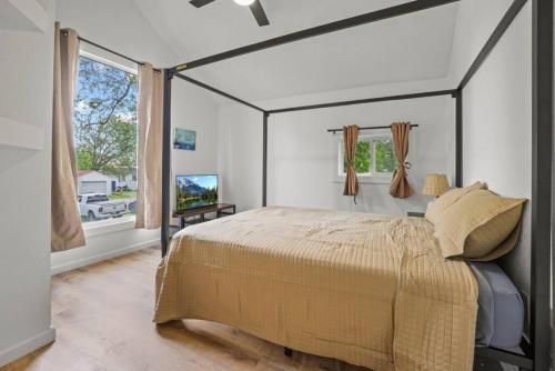 Buckeye LakeLuxury on Lakeside的一间卧室设有一张天蓬床和一台电视机。