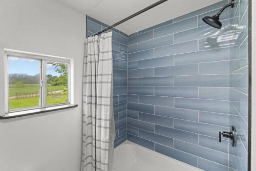 Buckeye LakeLuxury on Lakeside的带淋浴的浴室，墙壁为蓝色瓷砖