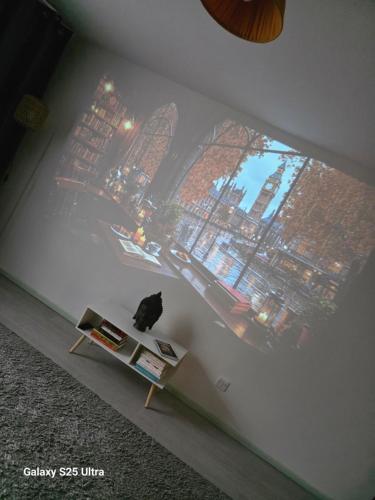 a cat sitting on a table in front of a wall at Green & White Haven-Spacious 3BR in London