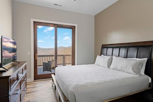 una camera da letto con un letto, una televisione e un balcone di Mountain View D - Luxury Condo, King Suite, Amazing View, Peace, and Hiking a Cullowhee