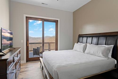 a bedroom with a bed and a television and a balcony at Mountain View 4 Units - Mountain Retreat, 8BR, Views, Near Smokies in Cullowhee