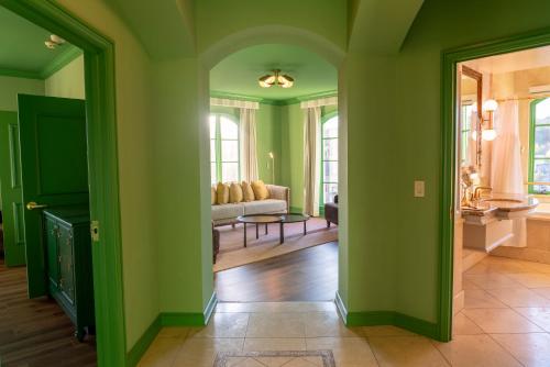 a living room with green walls and a couch at Carlton Hotel in Atascadero