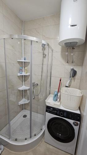 a shower with a washing machine in a bathroom at Dana in Banja Luka