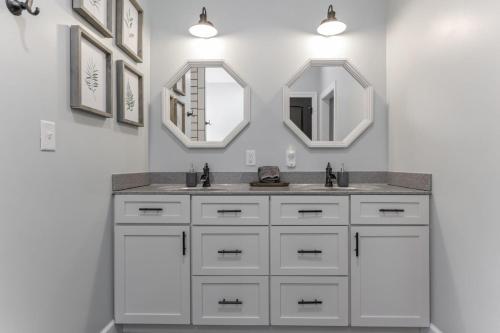 ein Badezimmer mit zwei Waschbecken und zwei Spiegeln in der Unterkunft Serenity on Siverly by Purple Munky Hospitality in Creola