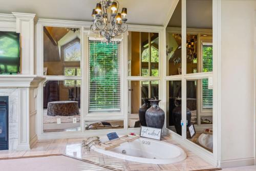 a large bathroom with a tub and a chandelier at Daisy Glen Retreat - Amazing Indoor Pool in South Bloomingville