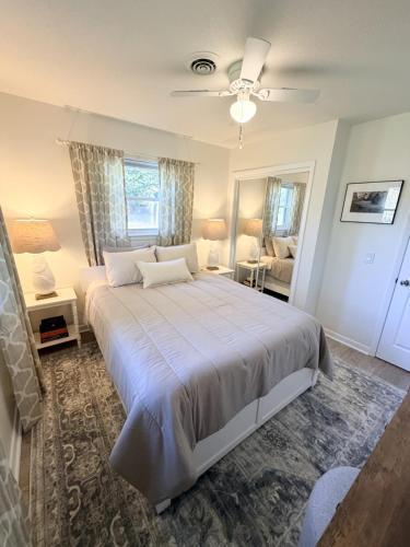 a bedroom with a large bed with a ceiling fan at Normandy Breeze in Wilmington