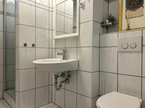 a white bathroom with a sink and a toilet at Central Studio for 2 in Hattersheim