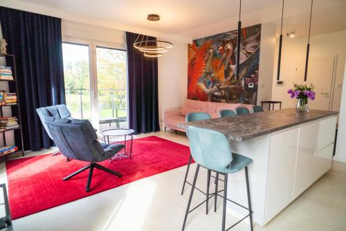 eine Küche mit blauen Stühlen und einem roten Teppich in der Unterkunft Marina Waterfront - najlepszy widok na Jeziorak in Iława