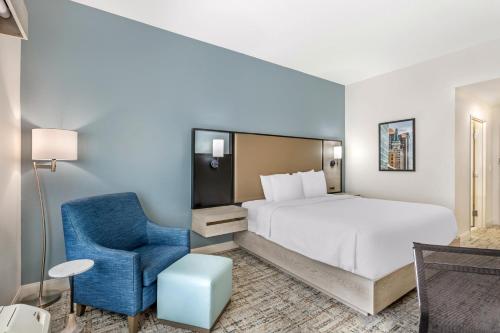 a hotel room with a bed and a blue chair at Best Western Plus Airport Inn & Suites in Salt Lake City