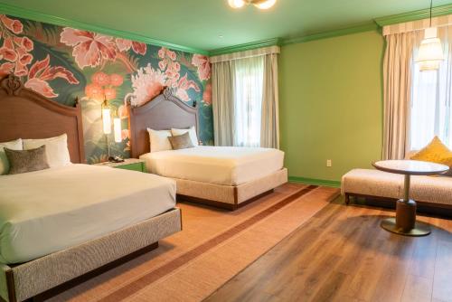 a bedroom with two beds and a floral wallpaper at Carlton Hotel in Atascadero