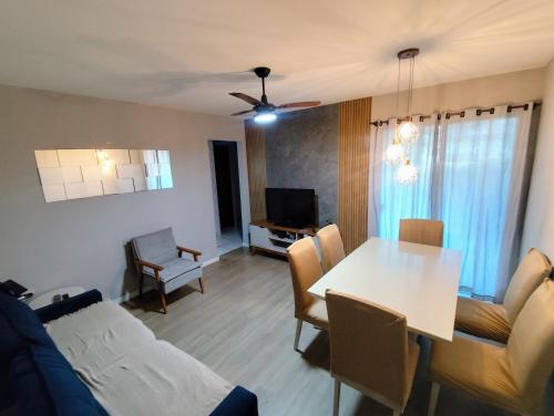 ein Wohnzimmer mit Tisch und ein Esszimmer in der Unterkunft Apartamento Térreo 2 Quartos Com Clube Privativo - Condomínio Marina Clube in Cabo Frio