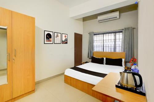una stanza d'albergo con un letto e una finestra di Super Townhouse Nanganallur Near Chennai Airport a Chennai