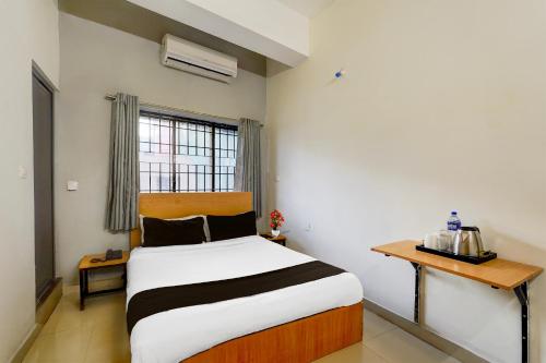 una camera da letto con un letto, un tavolo e una finestra di Super Townhouse Nanganallur Near Chennai Airport a Chennai