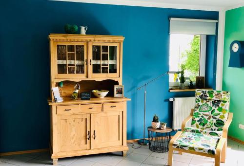 Una habitación azul con un armario de madera y una silla. en Fewo 5 Jahreszeiten, en Bell