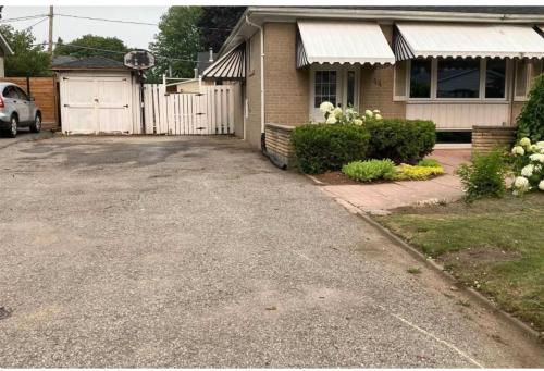 a driveway in front of a house with a garage at Soft Landing Spot Basement Hideout in Ajax