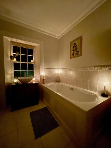 a large bathroom with a tub and a sink at Room 1, Wedale House in Stow