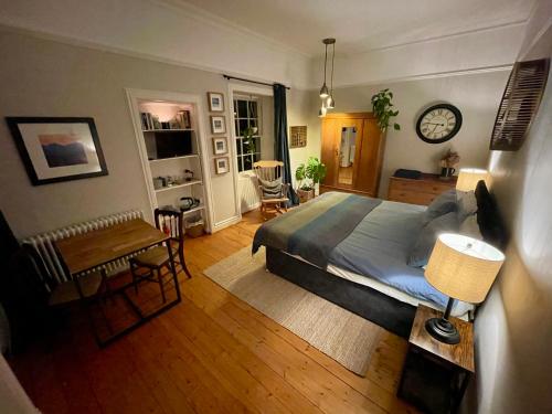 a bedroom with a bed and a table and a clock at Wedale House, first floor in Stow