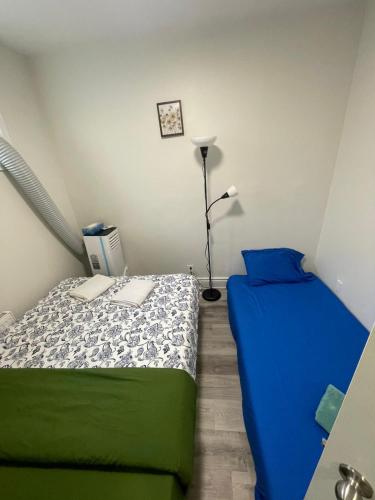 a small bedroom with two beds and a lamp at Exclusive Queen St Downtown Full House-PRIVATE PATIO in Toronto