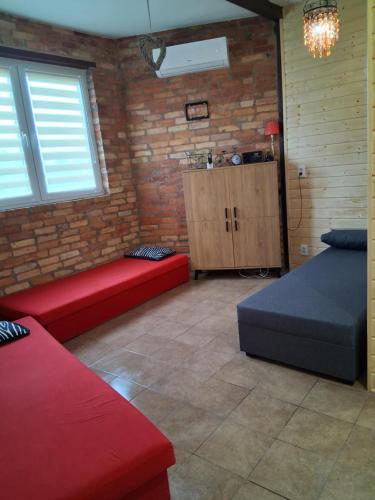 a room with red couches and a brick wall at NOCLEGI AGRO-RELAX in Kozielice