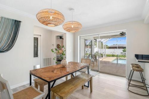 a dining room with a wooden table and chairs at Stylish coastal retreat with Heated Saltwater pool in Port Charlotte
