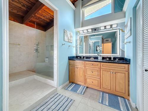 un bagno con doccia, lavandino e specchio di Luxury Maderia Beach waterfront home with pool-spa a St Pete Beach