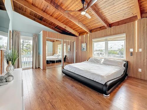 una camera da letto con un letto grande in una stanza con soffitti in legno di Luxury Maderia Beach waterfront home with pool-spa a St Pete Beach