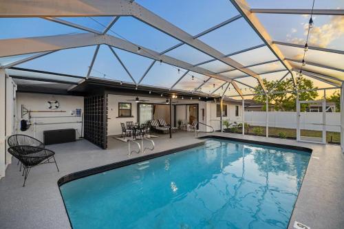 an indoor swimming pool with a large glass roof at Stylish coastal retreat with Heated Saltwater pool in Port Charlotte