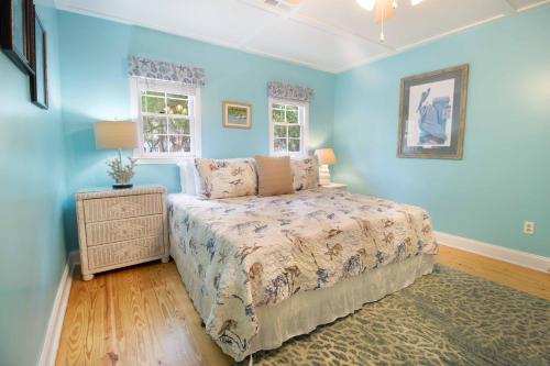 a blue bedroom with a bed and a night stand at Paws4ever II in Edisto Island