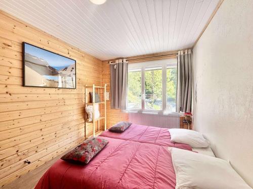 a bedroom with a large bed in a wooden wall at LA COUSINADE in Vénosc