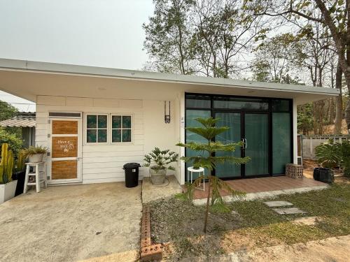 a small white house with a tree in front of it at Sandy house pai 3 in Kampong Huaibū