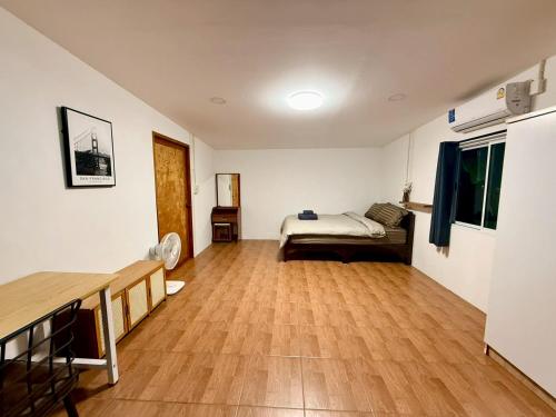 a living room with a bed and a wooden floor at Sandy house pai 3 in Kampong Huaibū