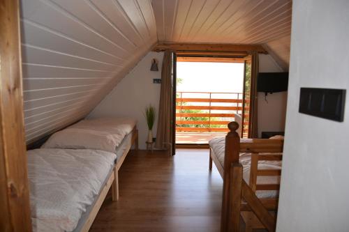 a room with two beds and a large window at Chata Šumavěnka in Bezděkov