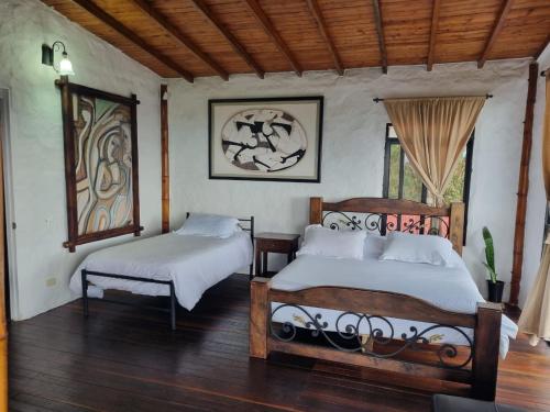 una camera da letto con due letti in una stanza di Casa Campestre La Montaña a Filandia