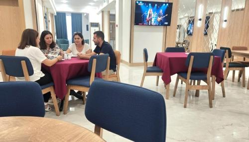 a group of people sitting at a table in a restaurant at Baku Khatai Central Hotel in Baku