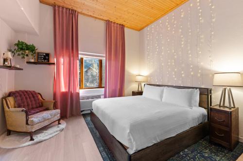 Un dormitorio con una cama y una silla y una ventana. en Gateway 5063, en Snake River Health Services Incorporated Heliport